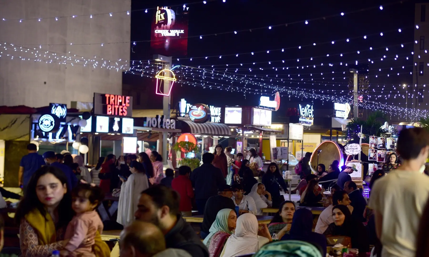 Karachiites enjoy a night out with families as kiosks serve a mix of traditional and western-style street food. &mdash; Tahir Jamal/White Star