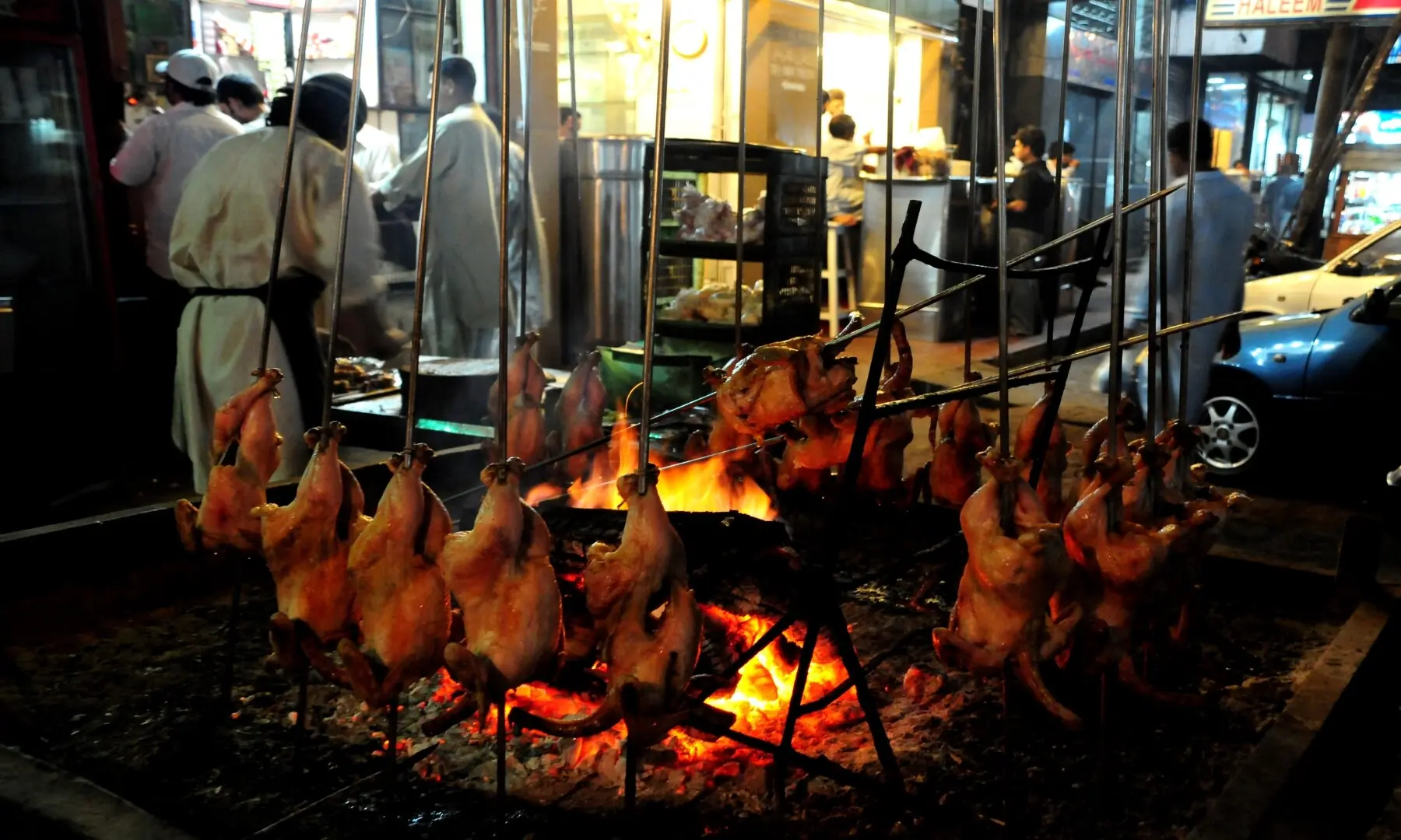 Whole chicken sajji being carefully roasted and basted at a bustling kiosk on Burns Road,  as the aroma of spices fill the night air. &mdash; Fahim Siddique/White Star