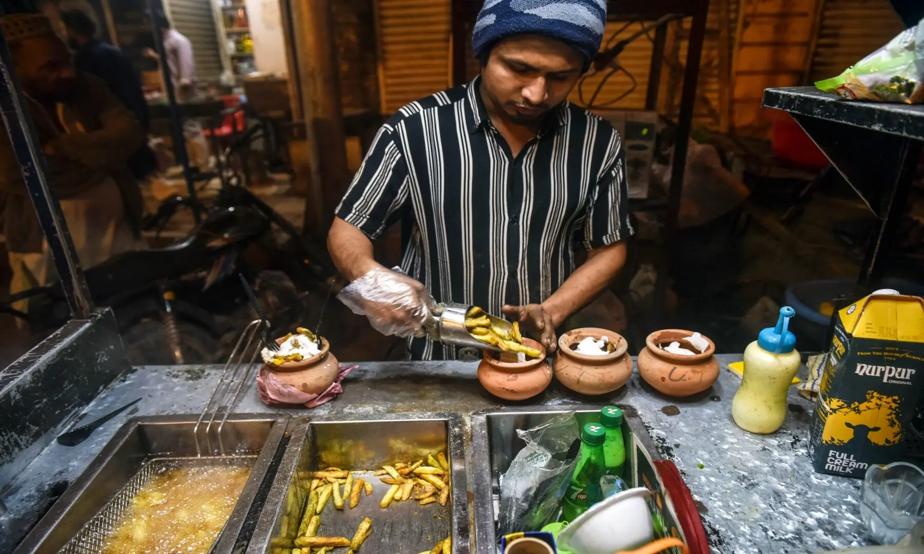Fries are being readied to serve in clay pots at the Burns Road kiosk, adding a traditional touch to this popular street snack loved by Karachiites. &mdash; Fahim Siddique/White Star
