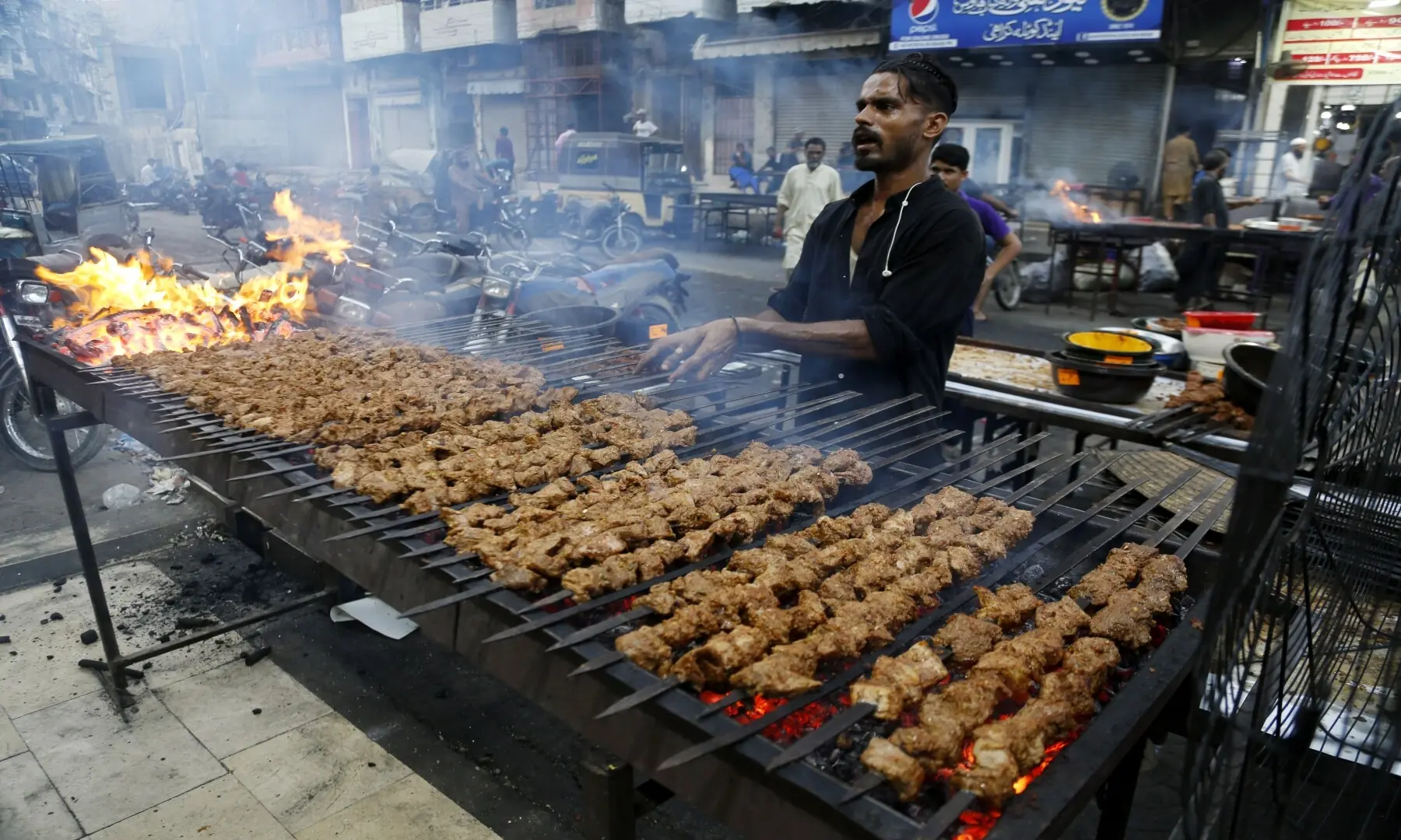 A person grills seekh kababs at Burns Road Food Street, skewered minced meat seasoned with aromatic spices, a favourite for late-night diners who flock to Karachi&rsquo;s streets for sizzling, flavour-packed bites. &mdash; Shakil Adil/White Star