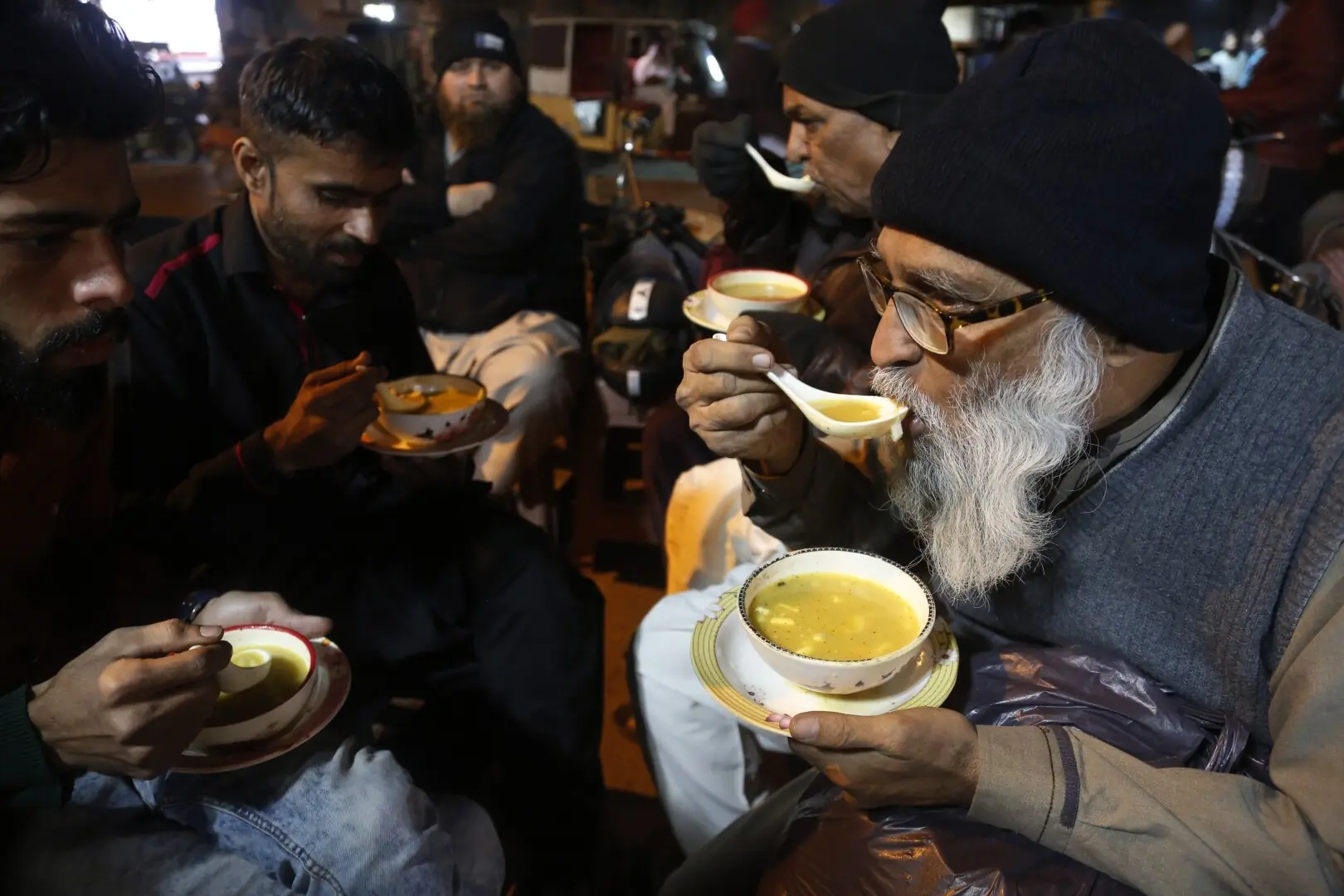 People enjoying street-style chicken soup at Burns Road, simmering with aromatic spices and tender meat, a comforting late-night favourite for Karachiites during winter months. &mdash;  Shakil Adil / White Star
