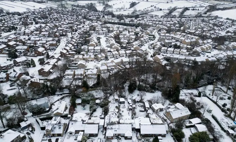 An aerial view shows snow-covered residential properties in Glossop, Derbyshire, northern England on January 6, 2026. &mdash;AFP