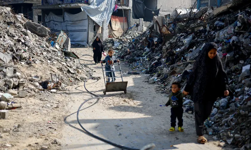 Palestinians walk past the rubble of residential buildings destroyed during the conflict, in Jabalia, northern Gaza Strip on January 6, 2026. — Reuters Palestinians walk past the rubble of residential buildings destroyed during the conflict, in Jabalia, northern Gaza Strip on January 6, 2026. — Reuters