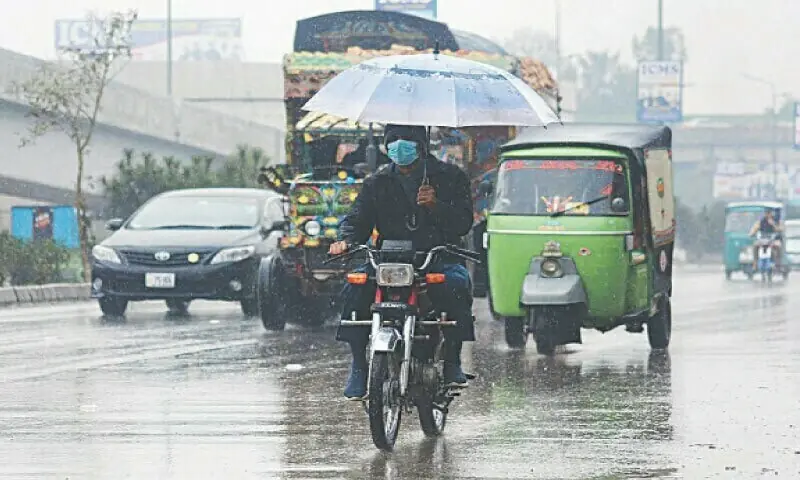 A biker holds an umbrella during rain in Peshawar in this undated file photo. — File/APP A biker holds an umbrella during rain in Peshawar in this undated file photo. — File/APP