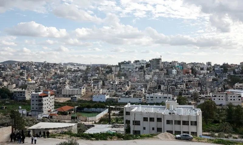 Palestinians look at Israeli heavy machinery demolishing a Palestinian building at Nur Shams refugee camp near Tulkarm, in the Israeli-occupied West Bank, on December 31, 2025. &mdash; Reuters