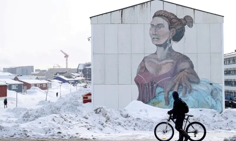A man passes a building with social housing with an Inuit mural in Nuuk, Greenland, March 27, 2025. &mdash;Reuters/File