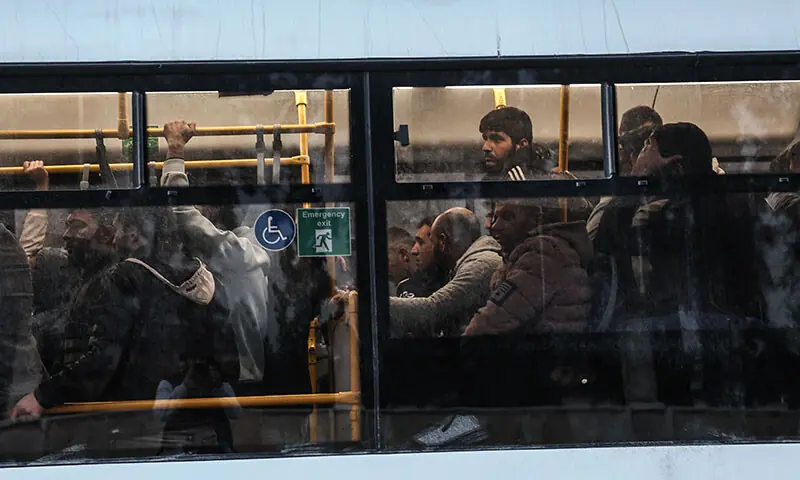 Kurdish fighters sit in a bus as they leave the Kurdish-majority Sheikh Maqsud neighbourhood accompanied by security forces in Aleppo, Syria on January 10. — AFP