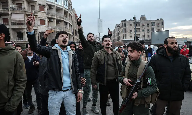 Residents react as a bus carrying Kurdish fighters prepares to leave the Kurdish-majority Sheikh Maqsud neighbourhood accompanied by security forces in Aleppo, Syria on January 10. — AFP