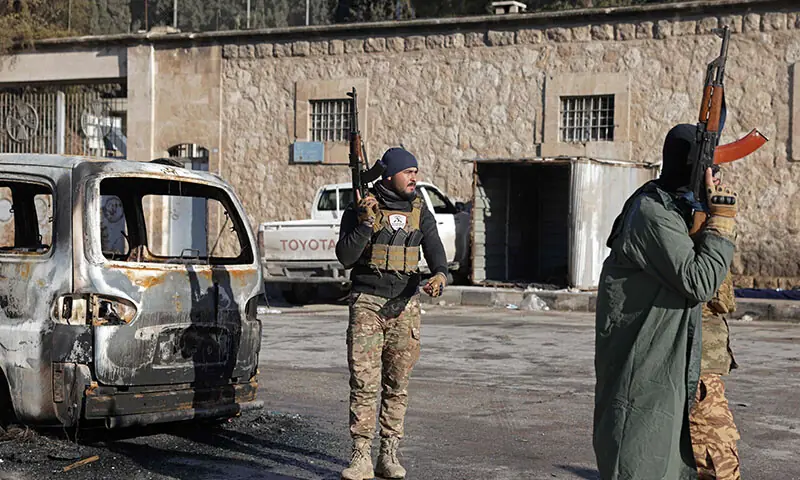 Members of Syrian government security forces stand guard along a street in the Sheikh Maqsud neighbourhood of Aleppo, Syria on January 10. — AFP
