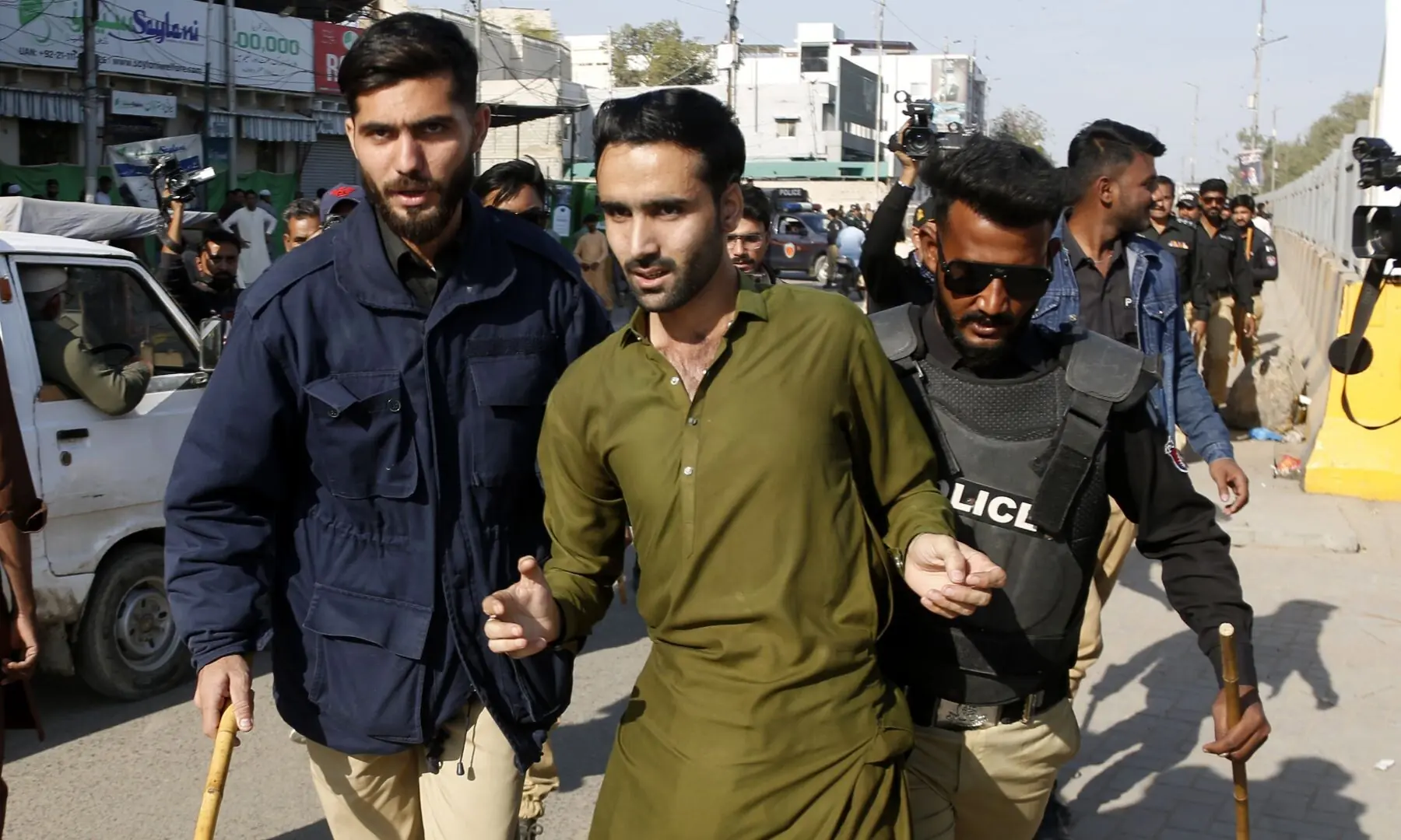 Police detain a PTI supporter gathered near Numaish Chowrangi, Karachi ahead of a PTI rally, on Jan 11, 2026. — Shakil Adil/White Star
