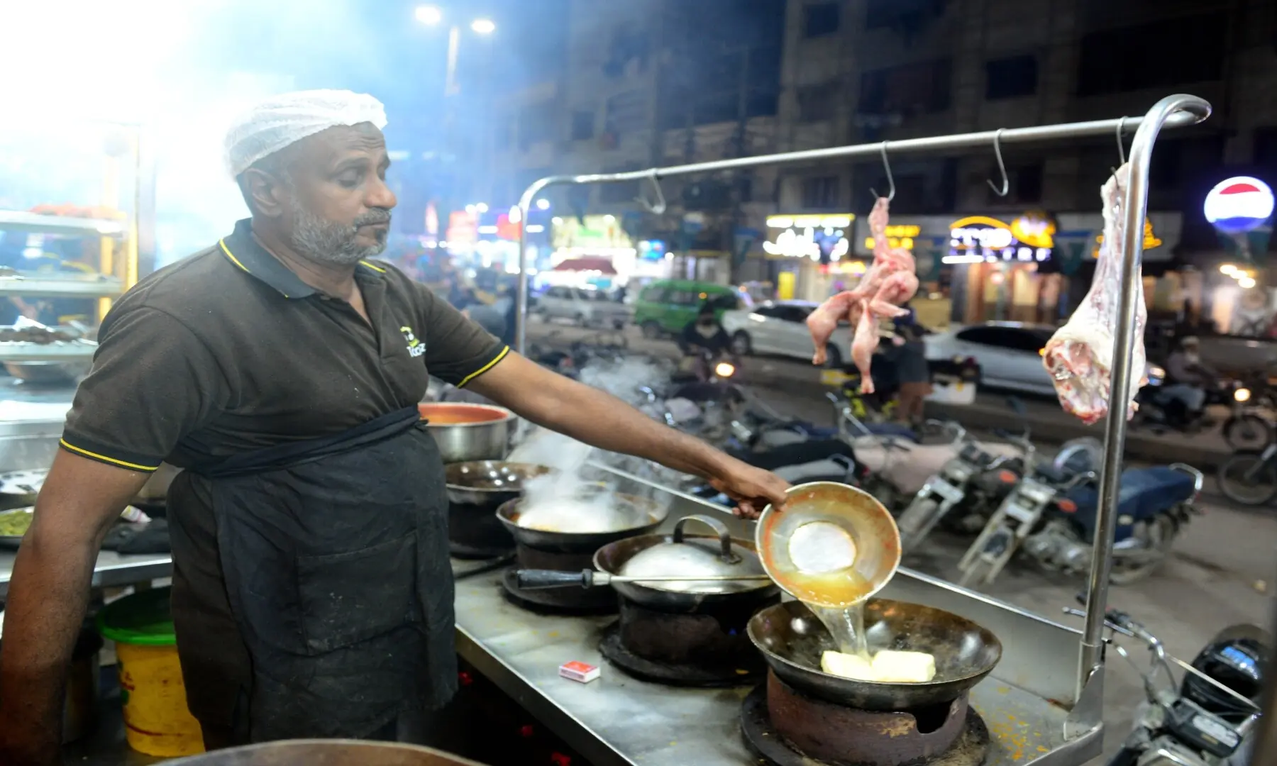 A man prepares karhai at his kiosk in Hussainabad, &mdash; Tahir Jamal/White Star