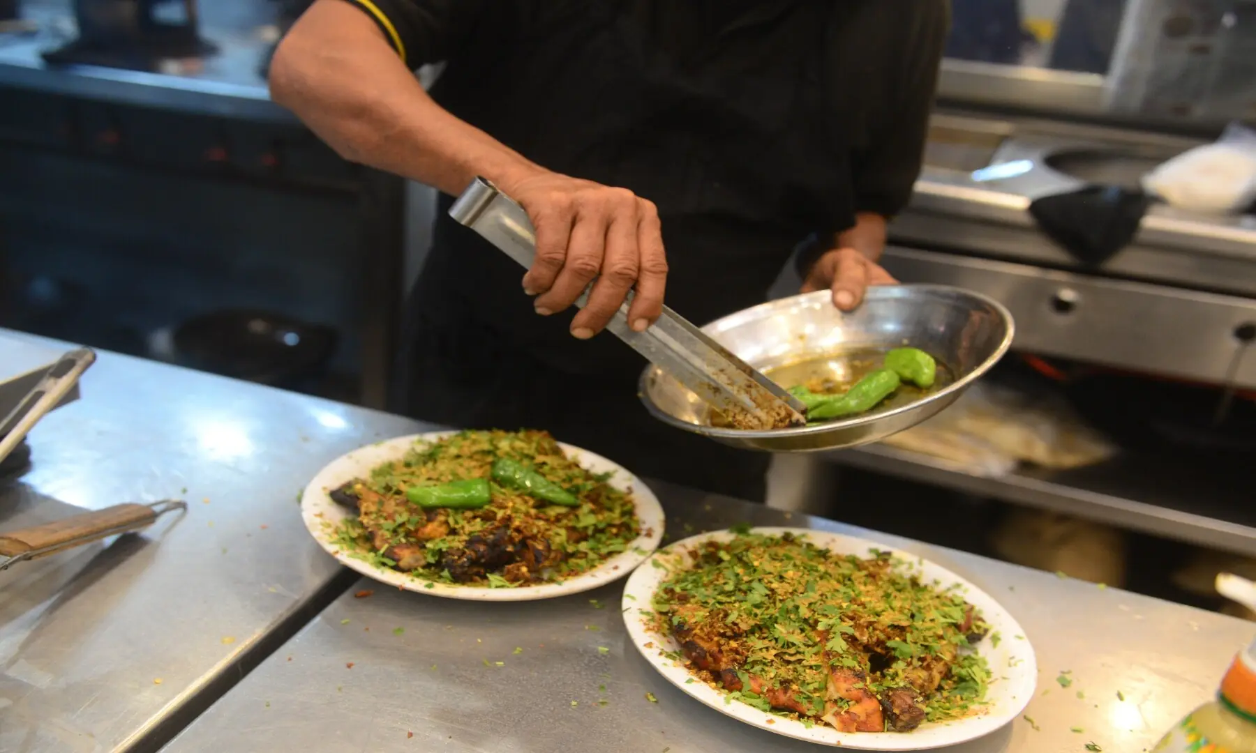 A vendor plates food at a bustling outlet in Hussainabad, serving up a mix of traditional and modern street favourites to eager food enthusiasts.&mdash; Tahir Jamal/White Star