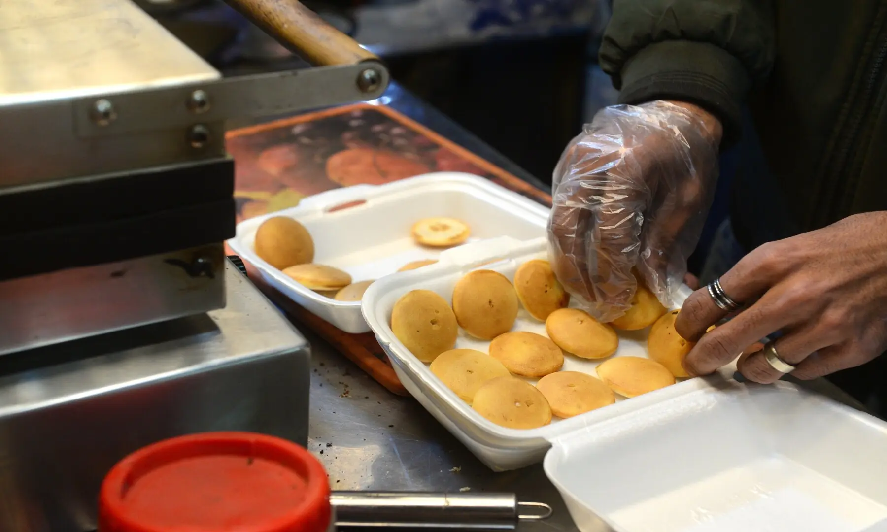 A vendor carefully lines up mini pancakes in a box at Hussainabad Food Street, blending sweet treats with the area&rsquo;s bustling street food offerings. &mdash; Tahir Jamal /White Star