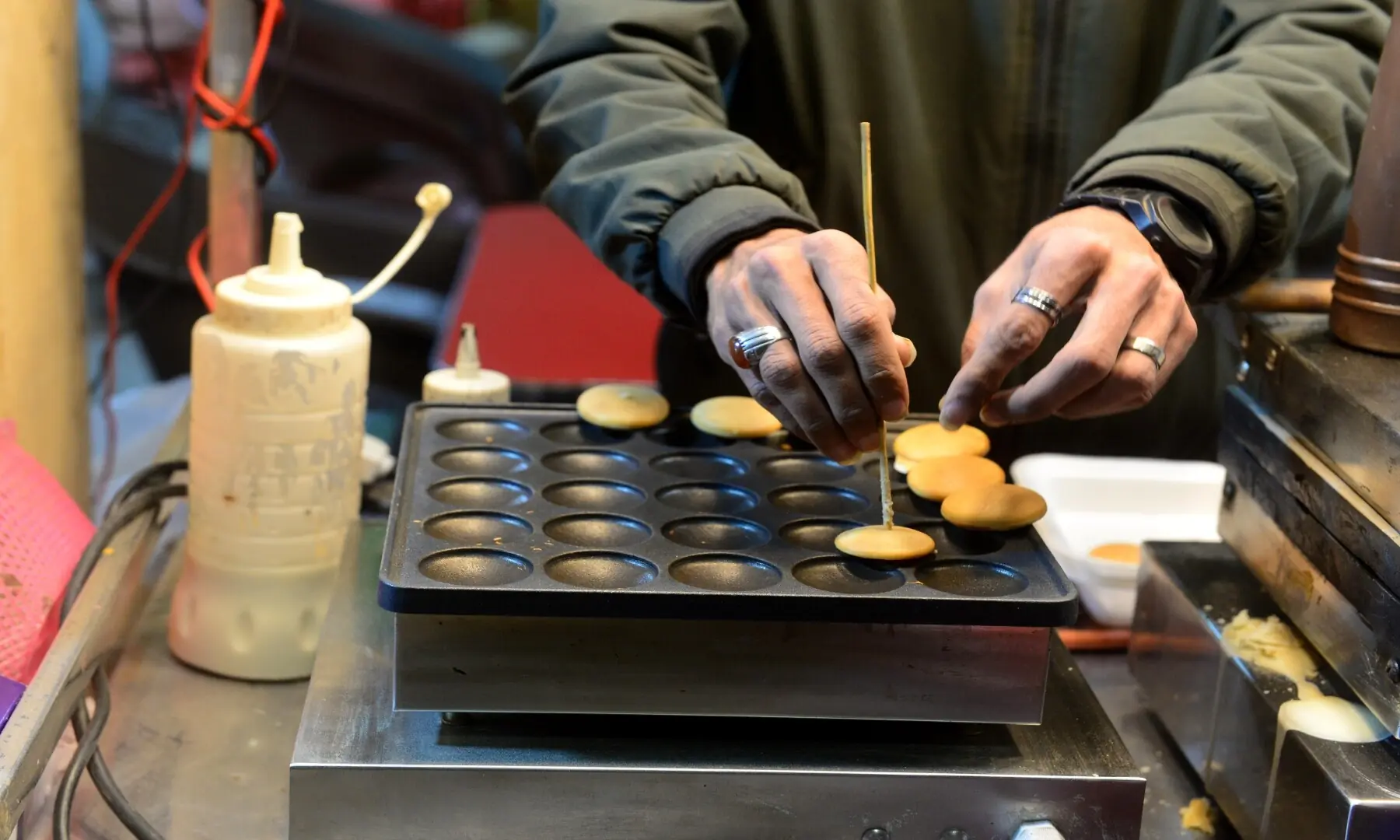 A person prepares mini pancakes at a food outlet in Hussainabad, showcasing how Western-style snacks have found a place alongside Karachi&rsquo;s traditional street food. &mdash; Tahir Jamal/White Star