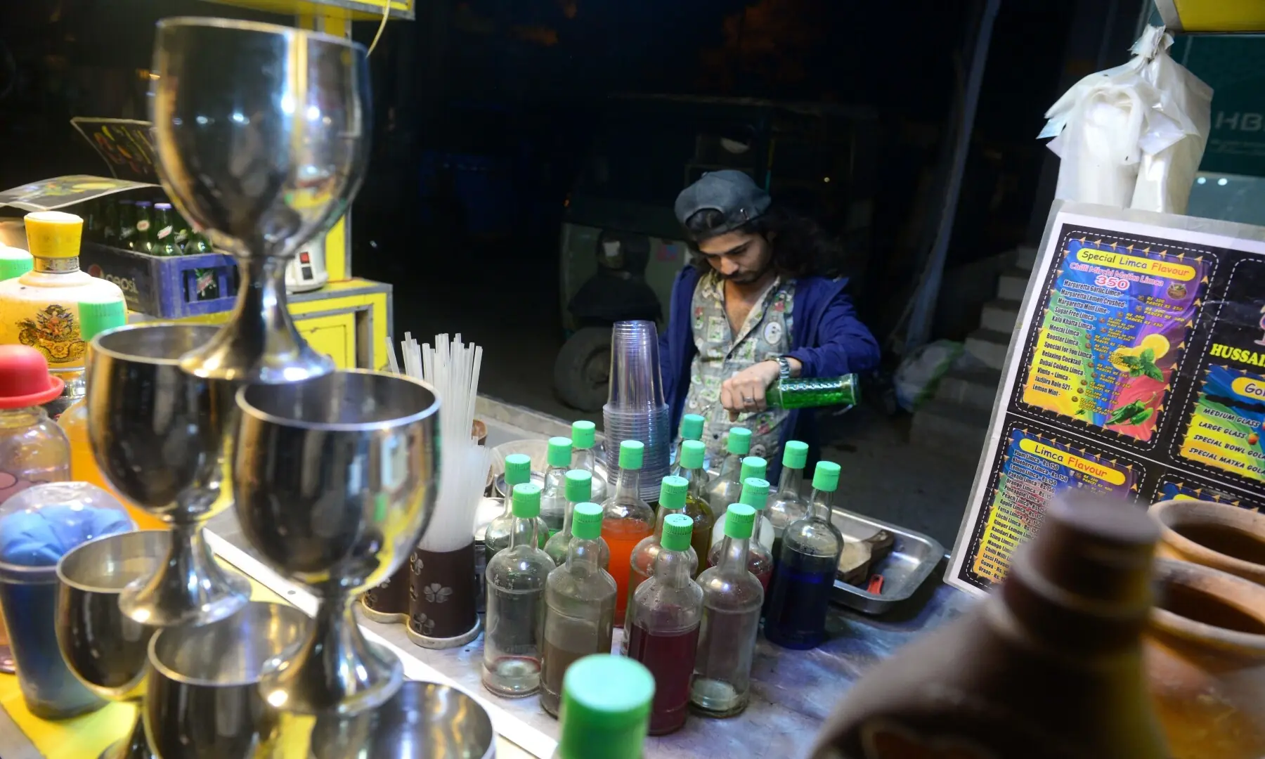 A vendor prepares refreshing drinks at his stall in Hussainabad, offering a cool respite amid the bustling street food scene &mdash; Tahir Jamal/White Star
