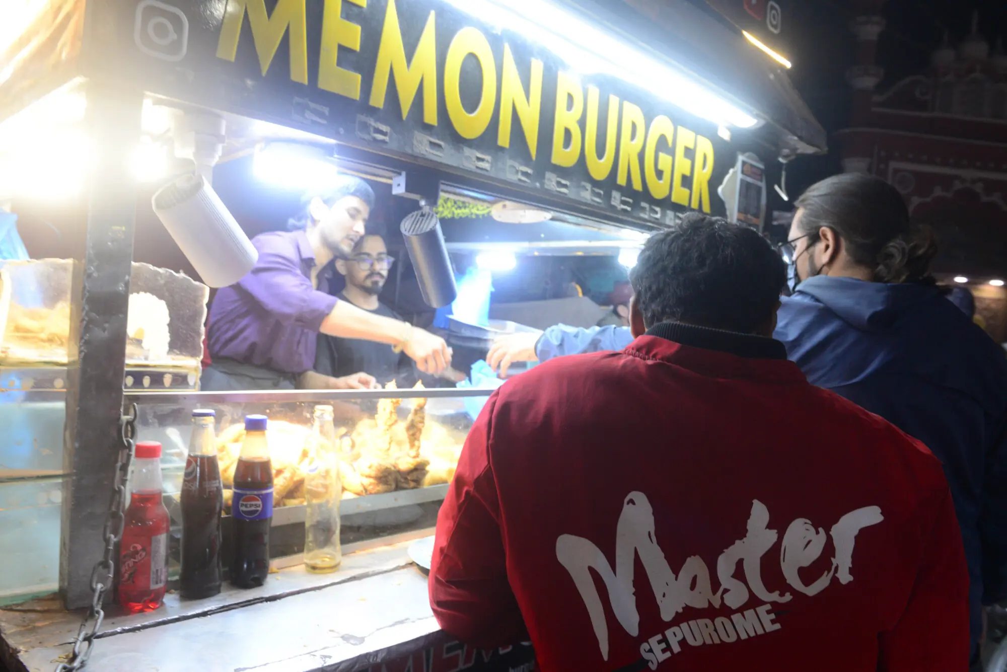 A vendor prepares burgers at a famous kiosk in Hussainabad.  &mdash; Tahir Jamall/White Star