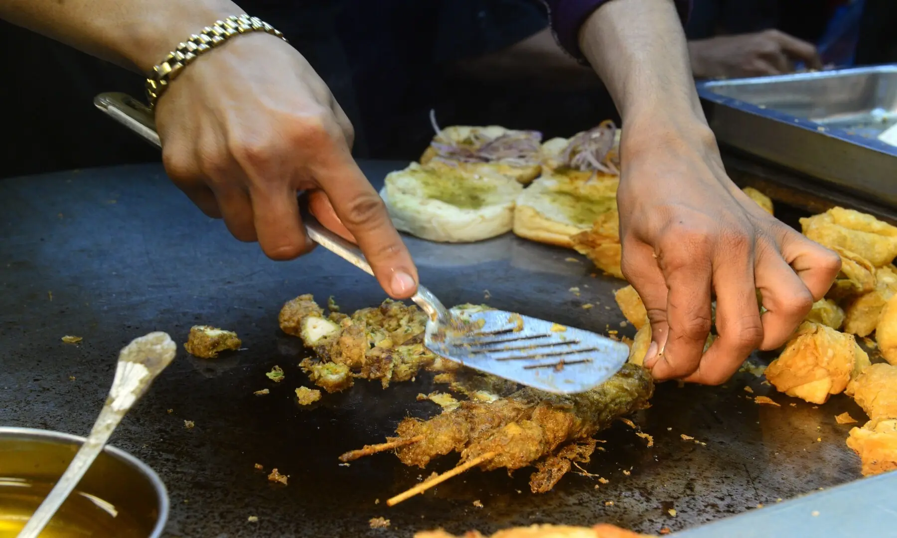 A vendor fries chicken sticks at a kiosk in Hussainabad, serving crispy, flavour-packed bites that are a hit with Karachi&rsquo;s street food lovers. &mdash; Tahir Jamal/White Star