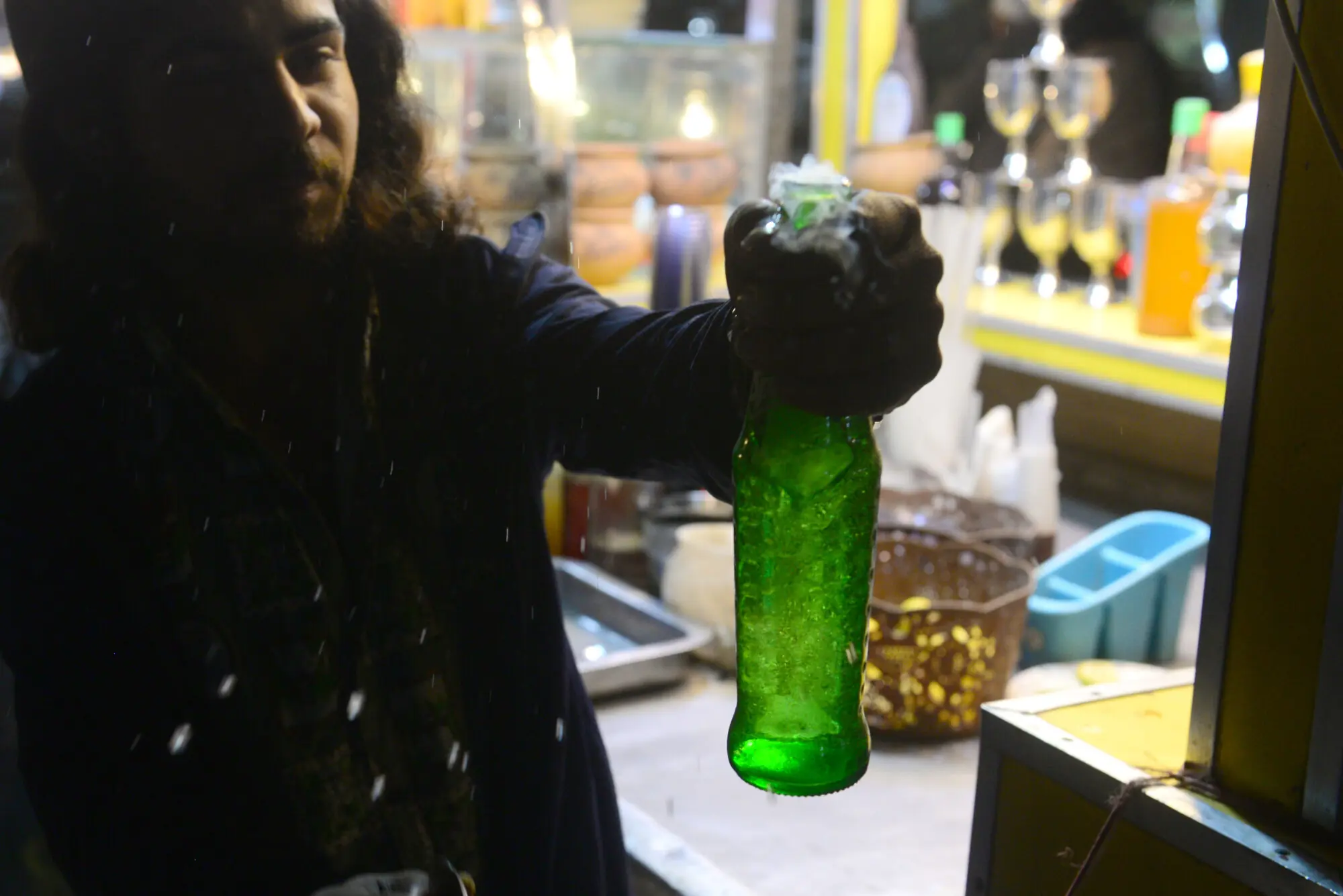 A vendor serves a chilled cold drink to a customer at Hussainabad, offering a refreshing pause amid the bustling street food scene. &mdash; Tahir Jamal