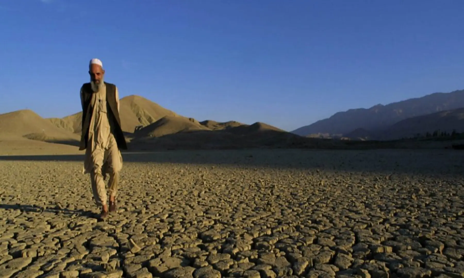 A man walks on the dried, cracked landscape near Hanna Lake near Quetta, Pakistan. &mdash; AFP/File