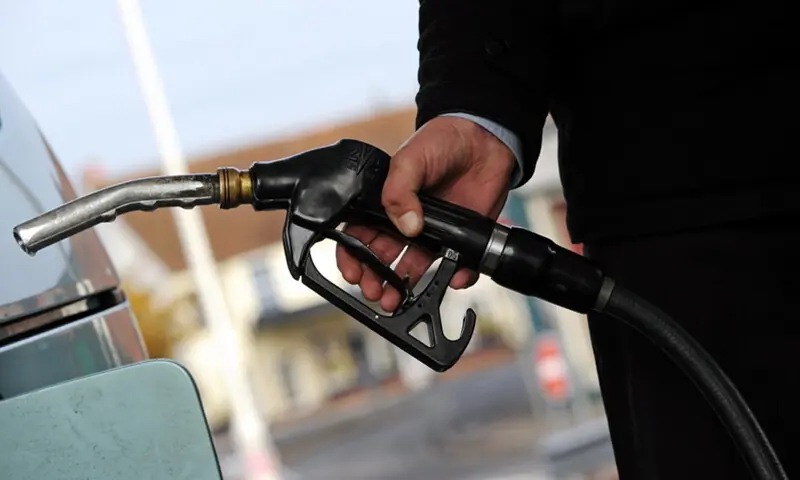 A person holding a fuel nozzle to fill fuel in a car. &mdash; AFP/File