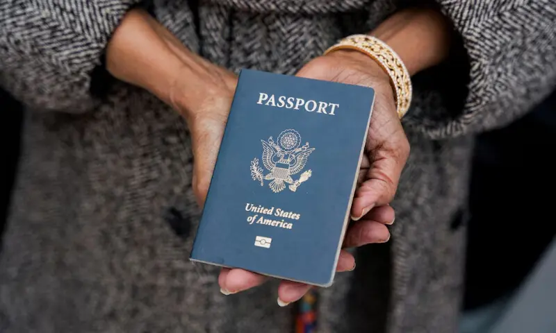 A woman holding a US passport, December 5, 2025. &mdash; REUTERS