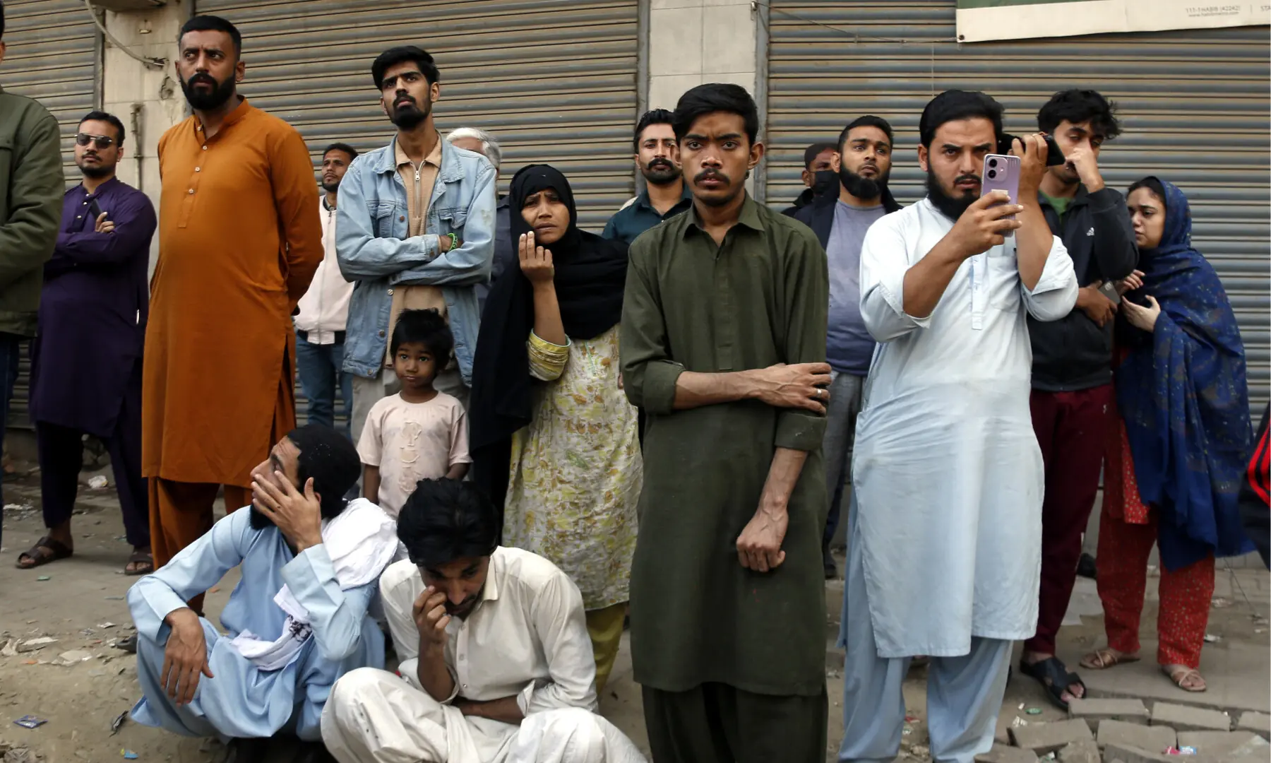 People look on as firefighters make efforts to douse a fire at the Gul Plaza shopping mall on Karachi’s MA Jinnah Road on Jan 18, 2026. — Shakil Adil/White Star