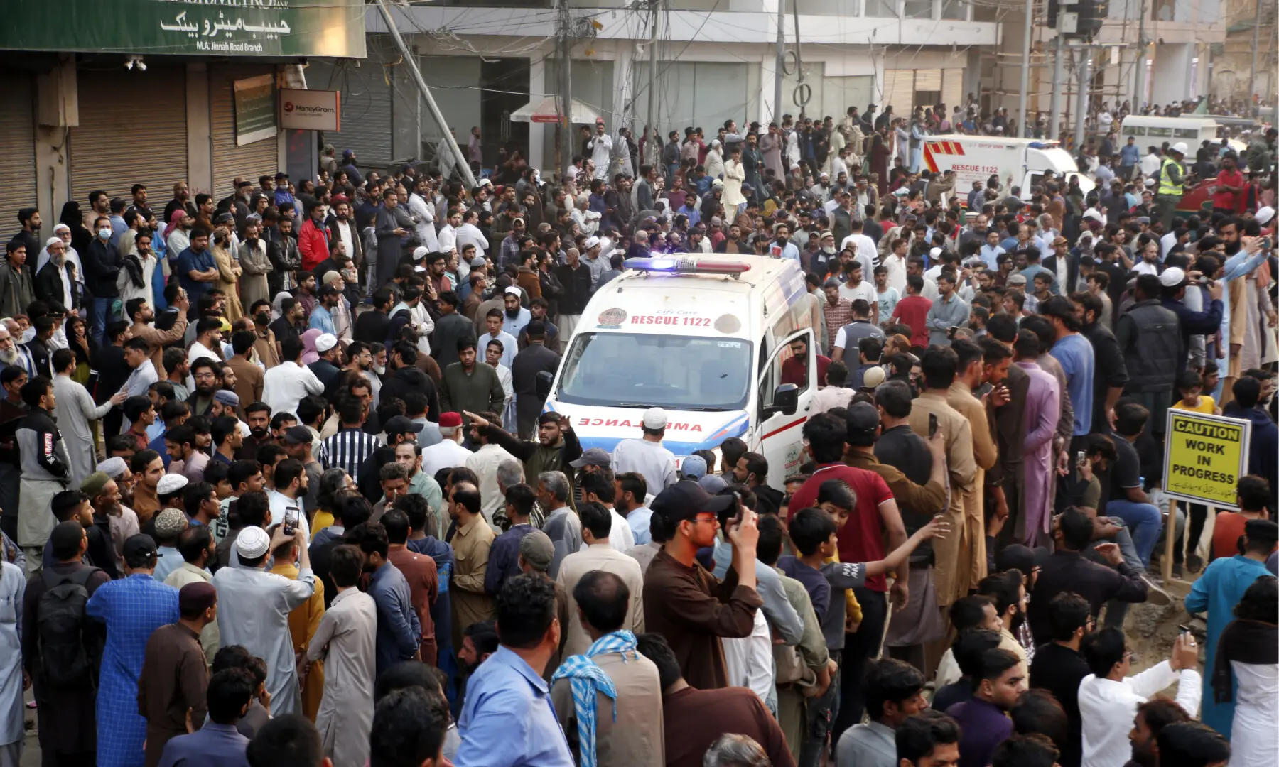 An ambulance makes its away among a crowd as efforts are underway to douse a fire at Karachi’s Gul Plaza shopping mall on Jan 18, 2026. — Shakil Adil/White Star