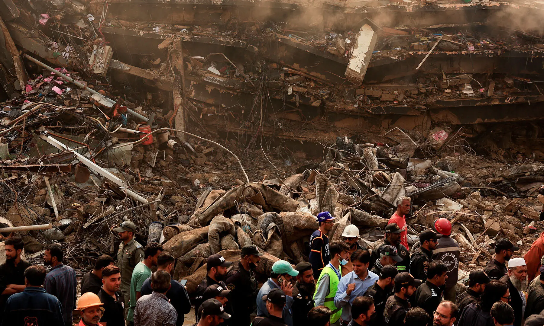  Police officers, rescue workers and shopkeepers gather at Karachi’s Gul Plaza shopping mall on January 19 after a massive fire broke out. — Reuters 