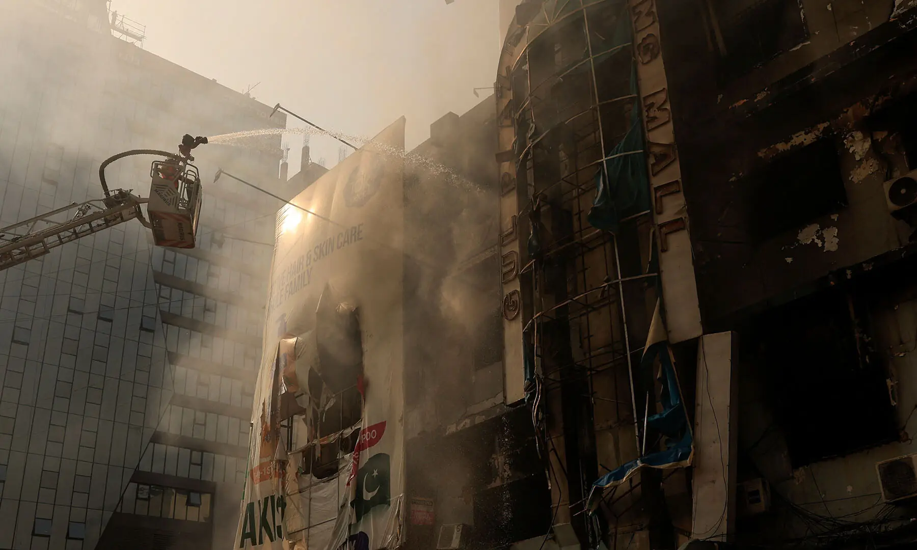 A firefighter works next to the smoldering remains of Karachi’s Gul Plaza shopping mall on January 19, following a massive fire that broke out. — Reuters