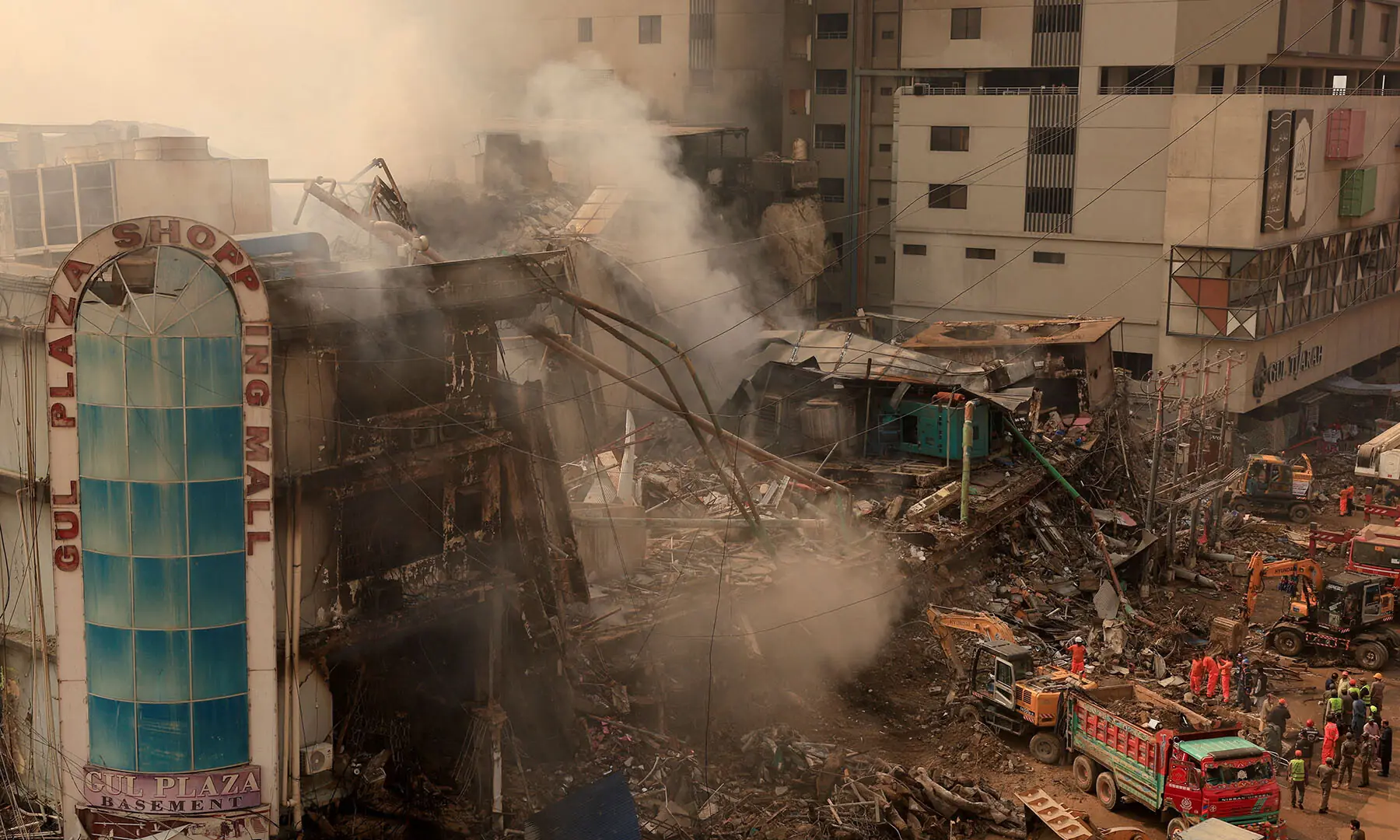  Workers remove debris on January 19 following a massive fire that broke out in Karachi’s Gul Plaza shopping mall. — Reuters 