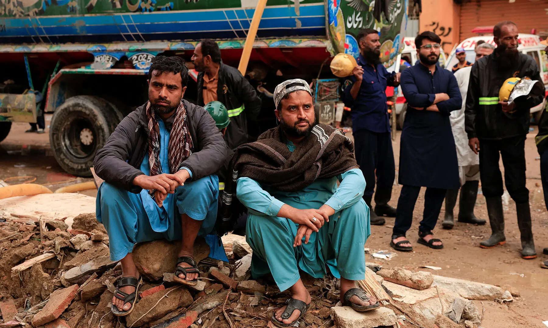  Shopkeepers observe rescue operations at Karachi’s Gul Plaza shopping mall on January 19, following a massive fire that broke out. — Reuters 