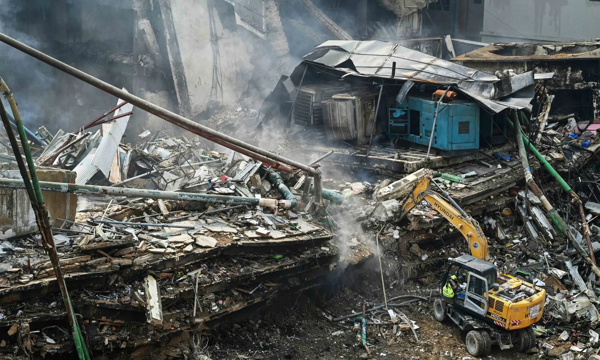 Rescue workers search amid the debris using excavators after a massive fire at a shopping mall in Karachi on January 19. — AFP