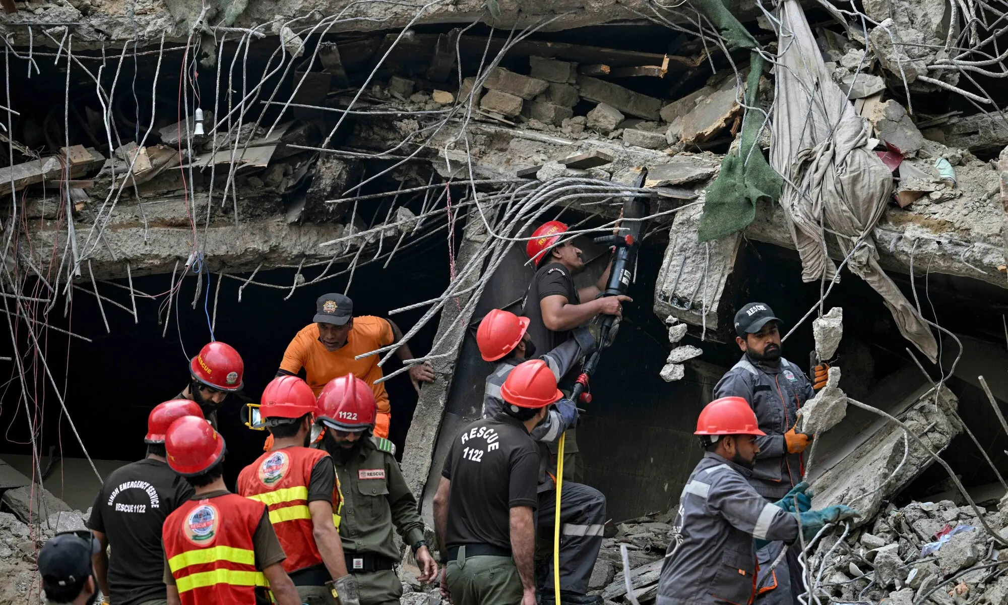 Rescue workers search amid the debris after a massive fire at a shopping mall in Karachi on January 19. — AFP