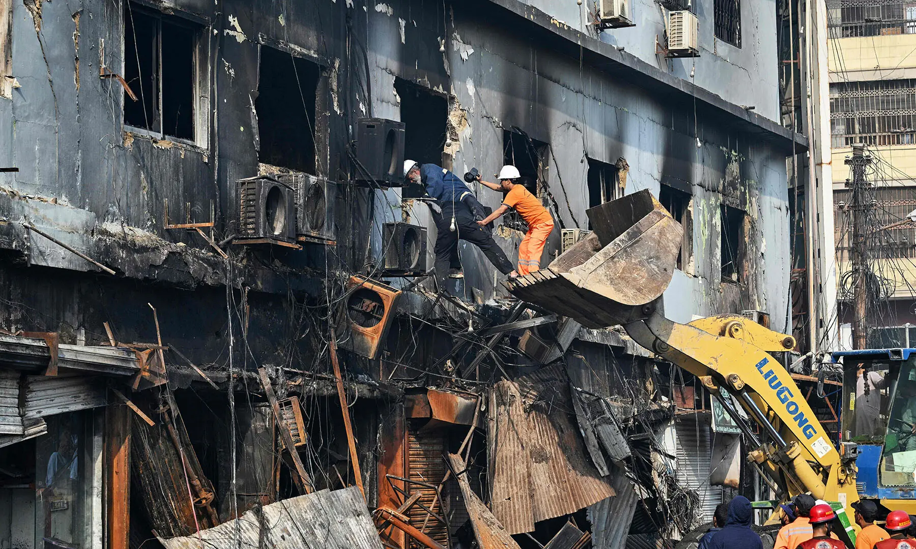 Rescue workers search the burned remains of Karachi’s Gul Plaza shopping mall on January 19 after a massive fire. — AFP