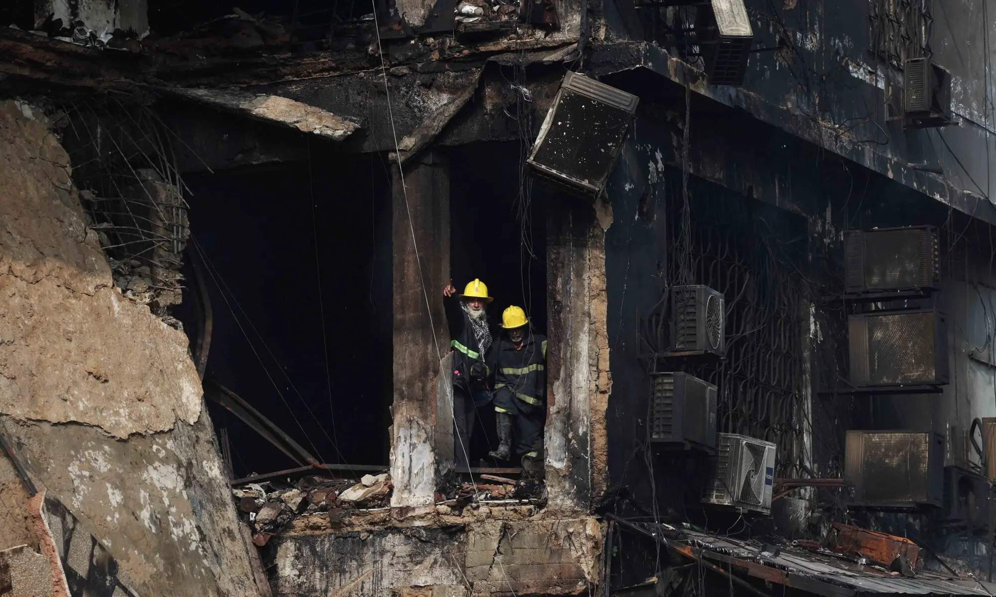 Rescue workers reacts as they stand amidst damaged property, following a massive fire that broke out in the Gul Plaza Shopping Mall in Karachi, Pakistan, January 19, 2026. &mdash; Reuters