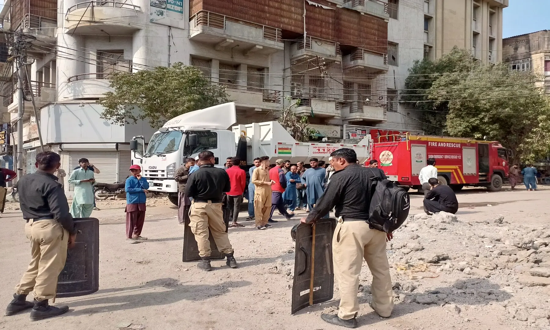  Policemen cordon off the area outside the Gul Plaza on Karachi&rsquo;s MA Jinnah Road, where a fire erupted on Saturday, January 17, killing 17 people. Fire trucks can be seen parked near the site, while citizens can be seen gathered around it. &mdash; Shazia Hasan 