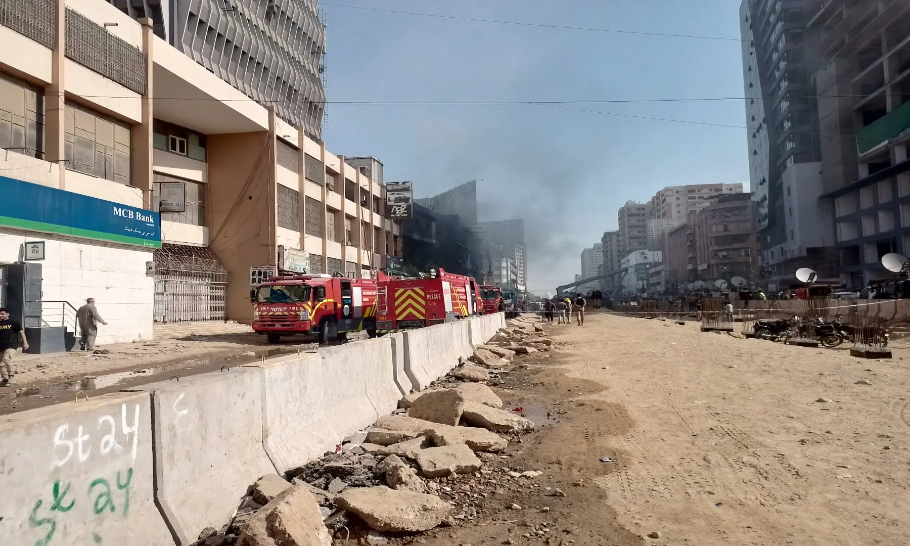  The charred Gul Plaza on Karachi&rsquo;s MA Jinnah Road seen from a distance as it exhales wisps of smoke &mdash; Shazia Hasan 