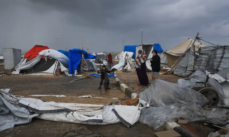 Displaced Palestinians gather near damaged tents, amid a windstorm, in Gaza City on January 13, 2026. — Reuters Displaced Palestinians gather near damaged tents, amid a windstorm, in Gaza City on January 13, 2026. — Reuters