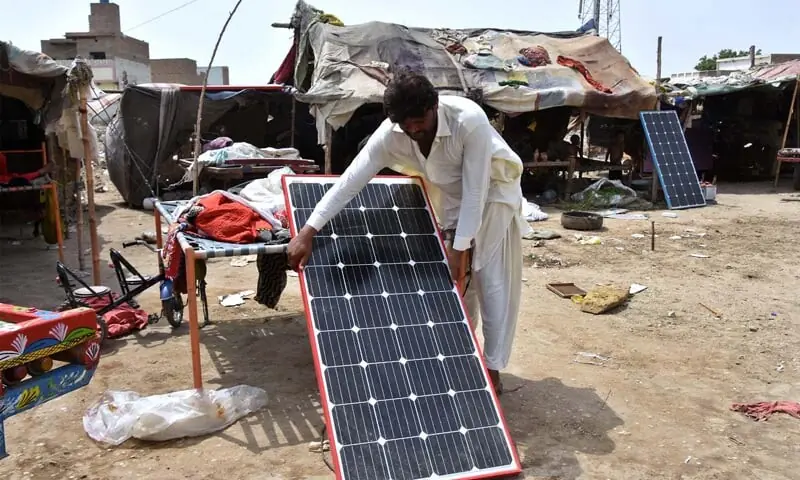 LARKANA: A man sets up a solar panel outside his makeshift house near Bakrani Road.&mdash;APP