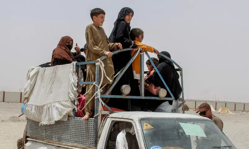 A REFUGEE family boards a vehicle at a holding centre near the border, as they depart for Afghanistan from Chaman.&mdash;AFP/File