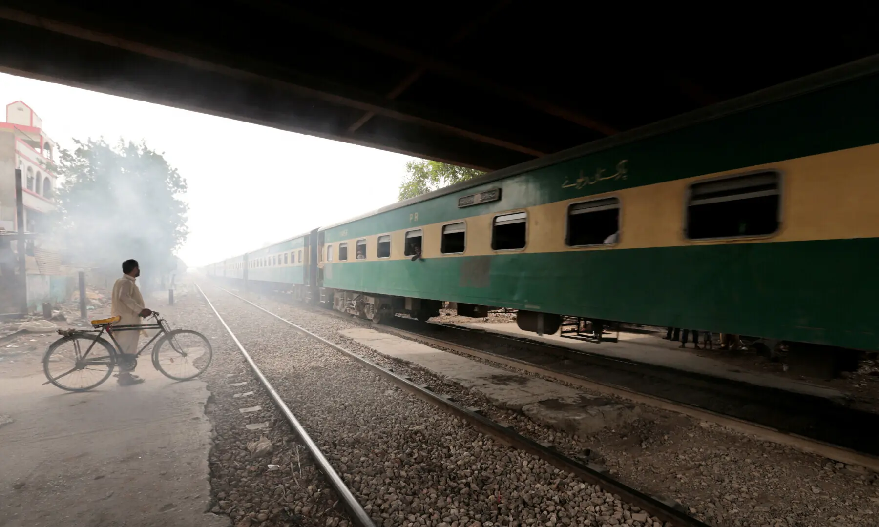 A man waits to cross a portion of track once shared with the disused Karachi Circular Railway line in Karachi on May 24, 2017. &mdash; Reuters/File