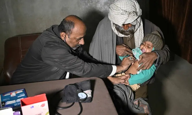 This photograph taken on January 8, 2026, shows a quack doctor Abdul Waheed (L) trying to diagnose a minor in his unlicensed clinic on the outskirts of Hyderabad. &mdash;AFP