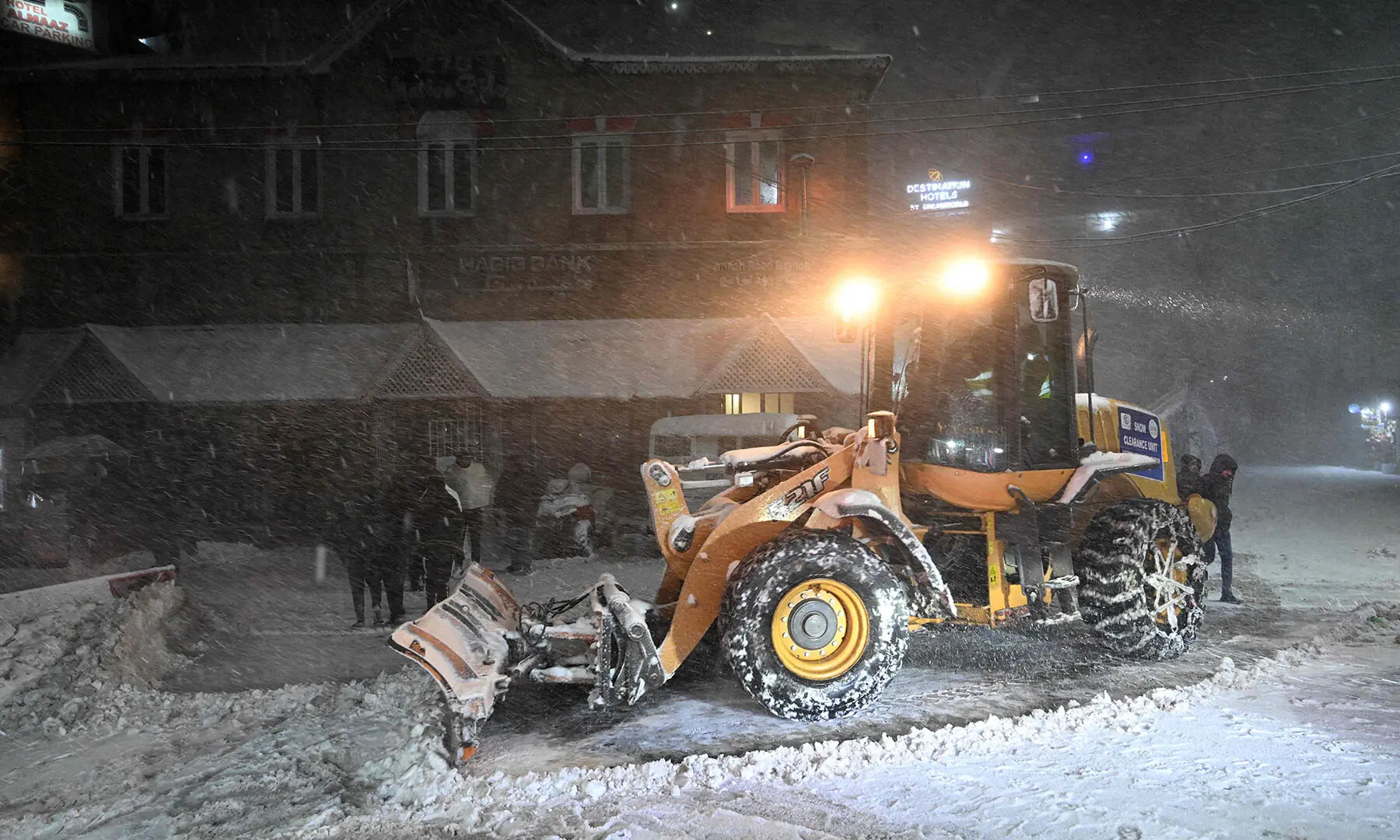 A bulldozer is used to clear heavy snow from a road in Murree on January 23. &mdash; AFP