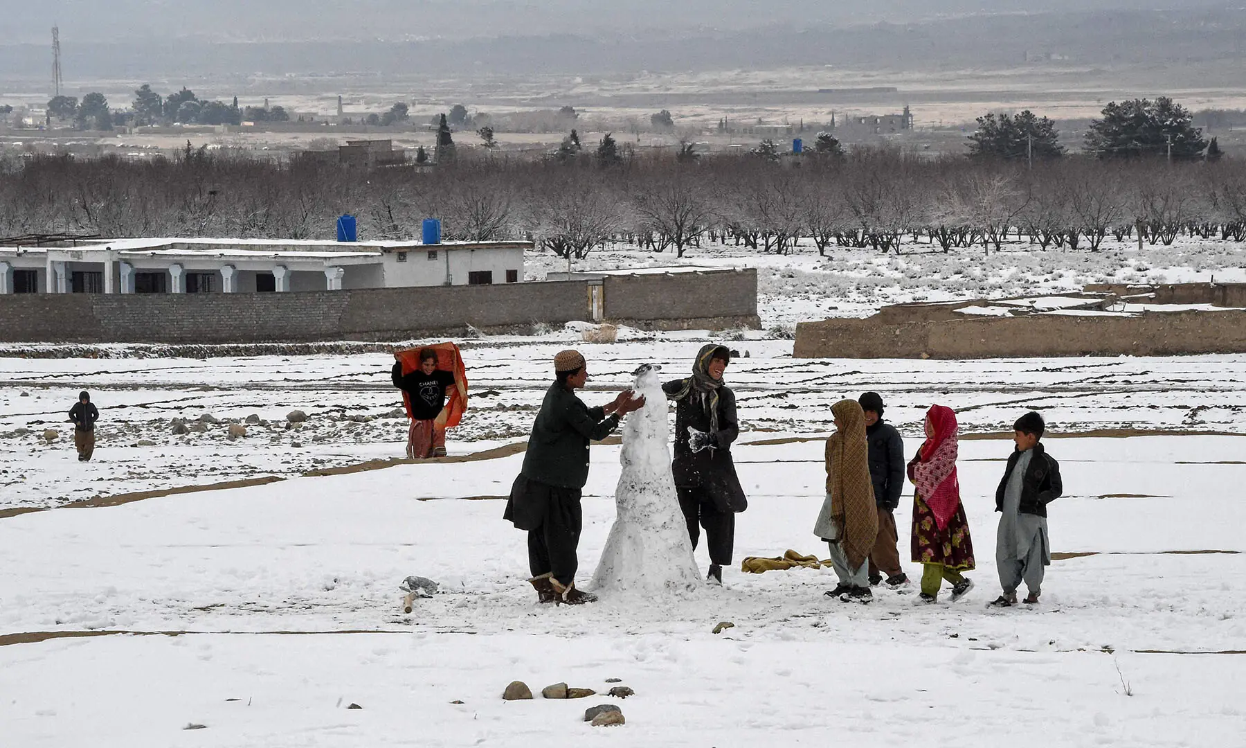 Children play in a snow-covered area on the outskirts of Quetta on January 22. &mdash; AFP