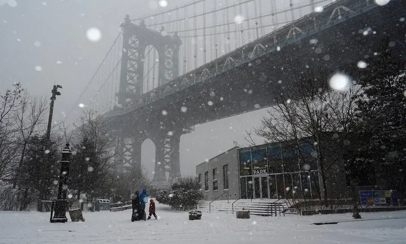 A family visits at Brooklyn Bridge Park, as Winter Storm Fern stretches across a large swath of the United States, in Brooklyn, New York City, US, January 25, 2026. &mdash; Reuters