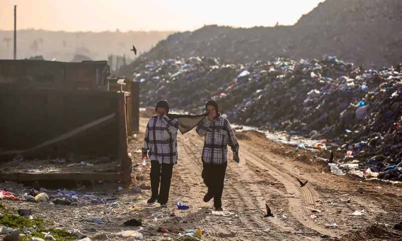 Palestinian women walk through a landfill in Khan Younis, in the southern Gaza Strip on January 25, 2026. &mdash; AFP