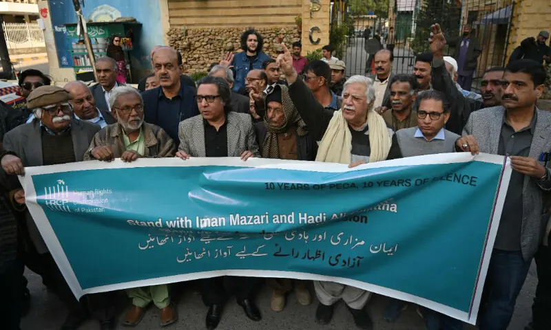 People holding a banner take part in a protest against the arrest of rights activist Imaan Mazari, in Karachi on January 26, 2026. - AFP