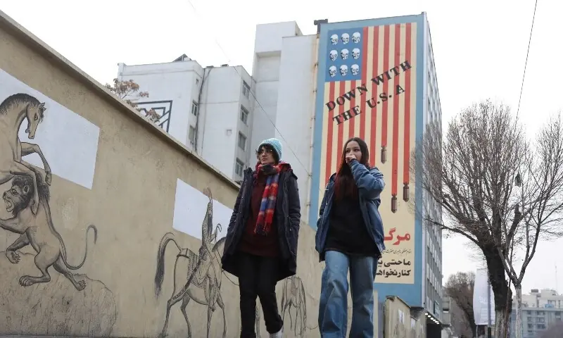 People walk next to an anti-US mural on a street as protests erupt over the collapse of the currency&rsquo;s value in Tehran, Iran, January 2. &mdash; Reuters/File