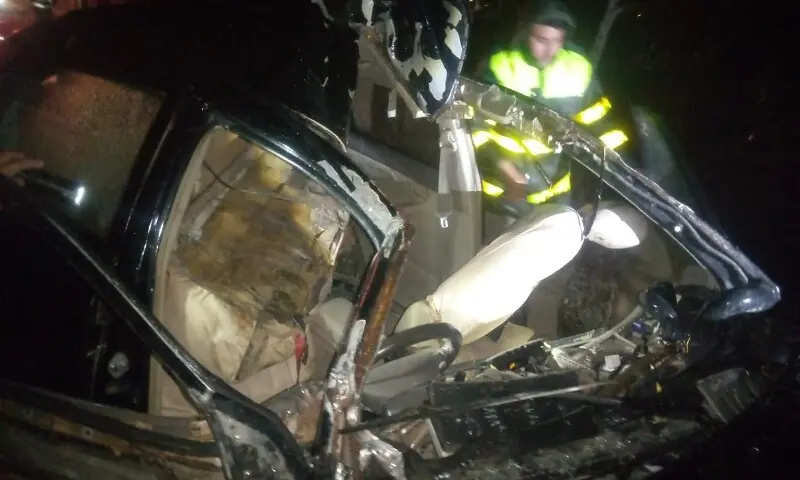 A rescue worker looks at a vehicle wreck following the road mishap on M-1. &mdash; Photo by author