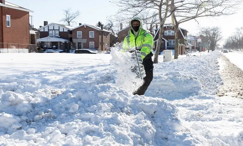 A city worker shovels heavy snow from a sidewalk in a residential neighborhood in the aftermath of a winter storm in the St. Louis area, Missouri, US, January 26, 2026. &mdash; Reuters